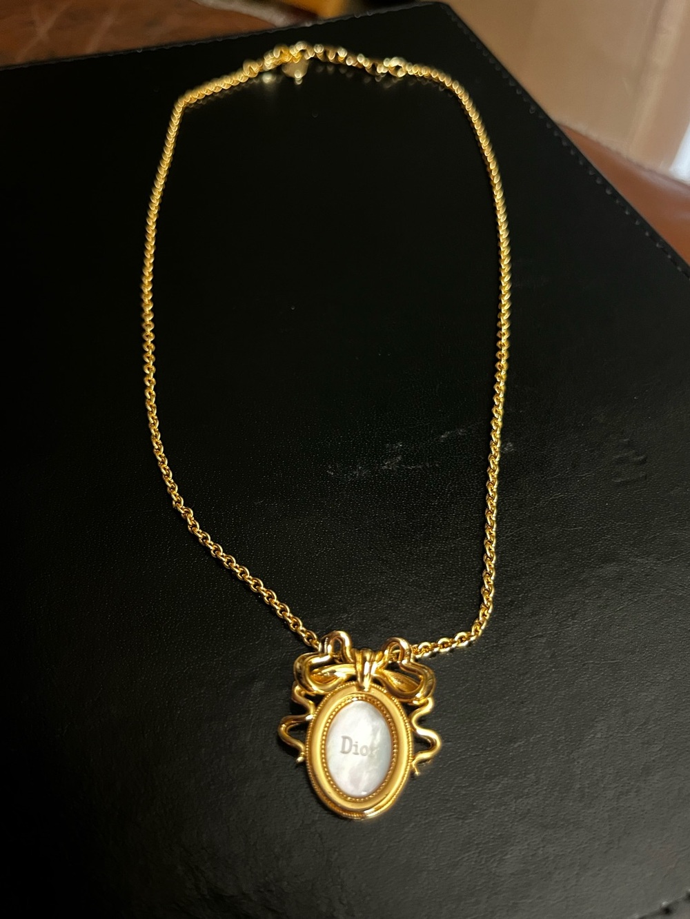 🎀 Dior. Gold Tone Bow Medallion Faux Mother of Pearl Pendant Necklace